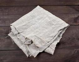 folded gray towel on brown wooden background photo