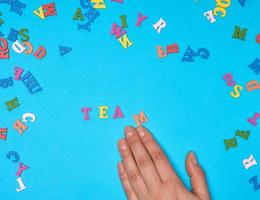 female hand and multicolored wooden letters of the English alphabet photo