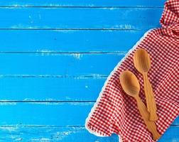 wooden spoon on a red kitchen towel, blue background photo