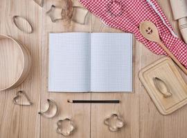 blank open notebook in line and wooden kitchen accessories photo