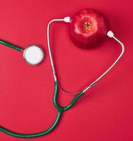 Ripe apple and green medical stethoscope photo