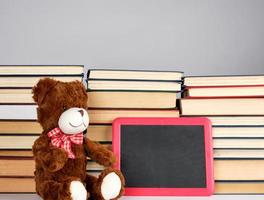 brown teddy bear and empty black board in red frame photo