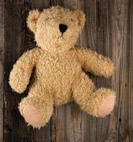small brown old teddy bear, gray old wooden background photo