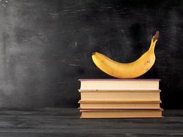 closed books with yellow sheets and ripe banana photo