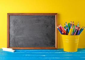 blank black chalk frame, white chalk and school supplies photo