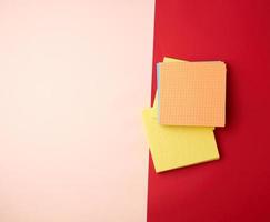 multi-colored square dishwashing sponges on a red-beige background photo