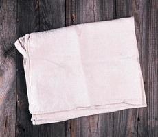 folded gray linen towel on wooden background photo
