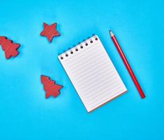 small notebook with empty white sheets in line and red wooden pencil photo