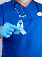 médico con uniforme y guantes de látex con una cinta azul en la mano foto