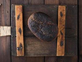 baked rye bread lies flour on a wooden old table photo