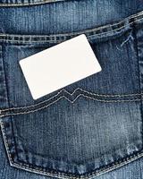 empty paper card lies on blue jeans photo