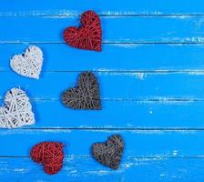wicker hearts on a blue wooden plank background photo