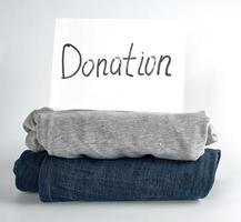 folded clothes and a white sheet of paper with the inscription donation photo