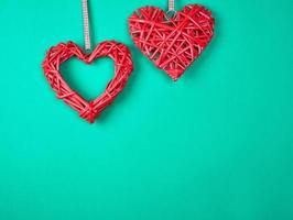 two wicker red hearts on a green background photo
