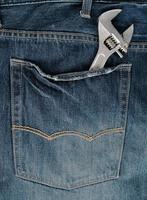 metal adjustable wrench in blue jeans back pocket photo