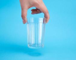 mano de mujer sosteniendo un vaso transparente vacío foto
