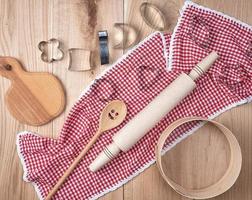 empty round wooden sieve and rolling pin on a red textile kitchen towel photo