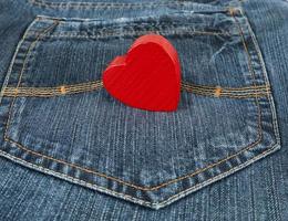 small red heart lies in the back pocket of blue jeans photo