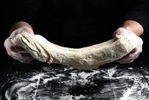 cocinero estira masa amasada de harina de trigo blanco foto
