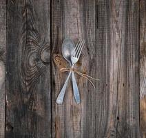 tenedor y cuchara de metal antiguo atados con una cuerda marrón foto