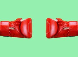 two female hands is wearing a red leather boxing glove on a green background photo