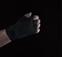 male right hand is wrapped in a black sports textile bandage photo