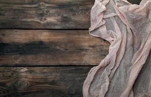 gray textile napkin, brown wooden background photo