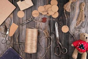 a coil of brown rope, paper tags and old scissors on a gray wooden background photo