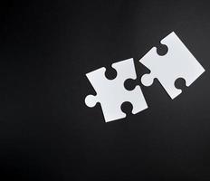two white big puzzles on a black background photo