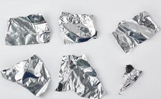 various pieces of silver  foil on a white background photo