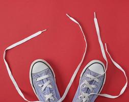 viejas zapatillas desgastadas con cordones blancos desatados foto