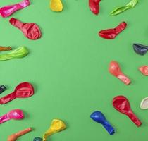 colorful deflated balloons on a green background photo