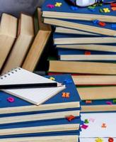 empty notebook with white sheets and many different books photo