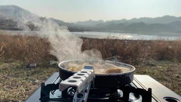soeppan met voedsel terwijl camping in de ochtend- video