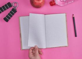 human hand turns over a notebook with empty sheets photo