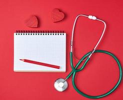 open blank notepad and green medical stethoscope photo