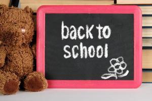 brown teddy bear and black board in red frame photo