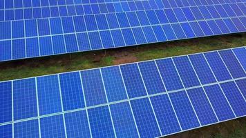 planta de energía solar en verano. baterías solares innovadoras en el campo. producción de energía limpia. vista aérea. video