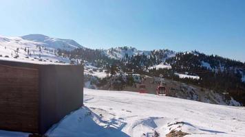 Cable way car in Goderdzi ski resort with old wooden houses in Adjara mountains in winter video