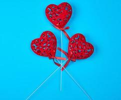 three red carved hearts on a stick photo