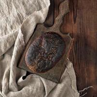 baked rye bread on a gray linen napkin, brown wooden table photo
