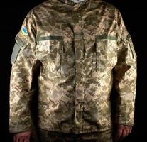 soldado ucraniano vestido con uniforme se para en la oscuridad foto