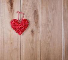 wooden background of oak boards and a red wicker heart photo