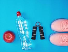 plastic water bottle, red ripe apple and sports expander photo