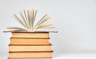 stack of books and an open book with yellow pages photo