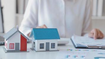 el agente de corretaje de bienes raíces entrega una muestra de una casa modelo al cliente, un contrato de préstamo hipotecario que arrienda y compra una casa y contrata el concepto de seguro de hogar