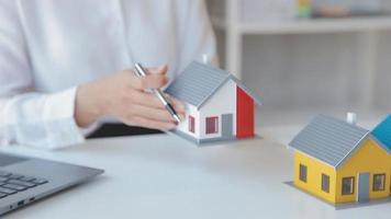 el agente de corretaje de bienes raíces entrega una muestra de una casa modelo al cliente, un contrato de préstamo hipotecario que arrienda y compra una casa y contrata el concepto de seguro de hogar