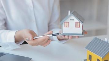 verklig egendom mäkleri ombud leverera en prov av en modell hus till de kund, inteckning lån avtal framställning hyra och uppköp en hus och kontrakt Hem försäkring begrepp