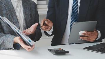 Financial analysts analyze business financial reports on a digital tablet planning investment project during a discussion at a meeting of corporate showing the results of their successful teamwork. video