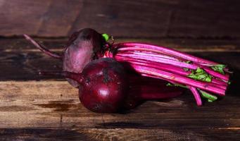 Two whole fresh beets with a tops photo